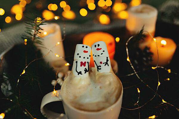 Marshmallow snowmans in the cup of coffee, bokeh lights, christm