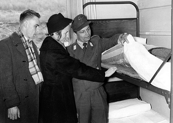 Conscript and mother inspecting a bed