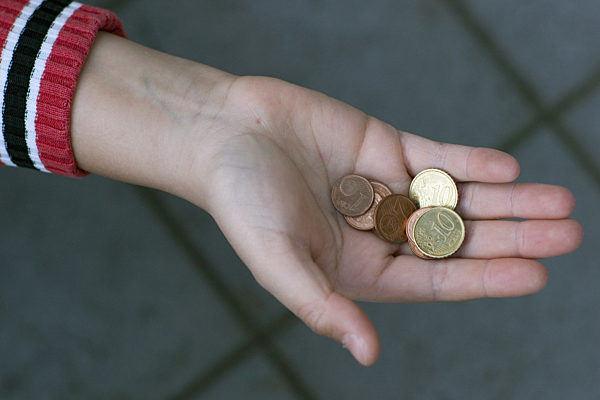 Kinderarmut - Kinderhand mit Euro-Centmünzen
