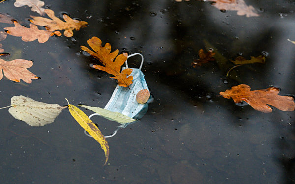 Einwegmaske schwimmt im Wasser