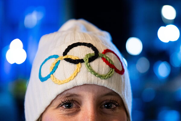 260202 A woman wears a winter hat with the Olympic rings during day -4 of...