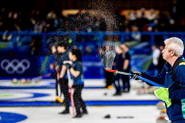 260207 A volunteer prepares the ice in a round robin mixed doubles curling...