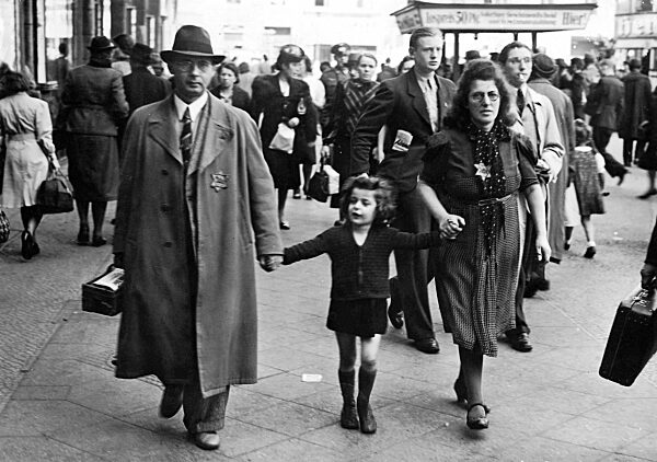 A Jewish family walking through a Berlin street wearing the Star of David on their lapels, 1941