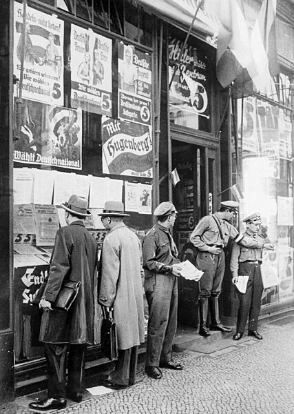 Passers-by in front of a polling station of the DNVP shortly before the Reichstag election on 31. July 1932.