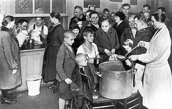 Families receive a warm meal in a Salvation Army soup kitchen in Germany, 1931