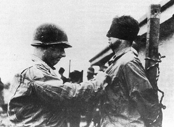 Amerikanischer Soldat verbindet einem Soldaten aus Skorzenys Kommando die Augen, 1944