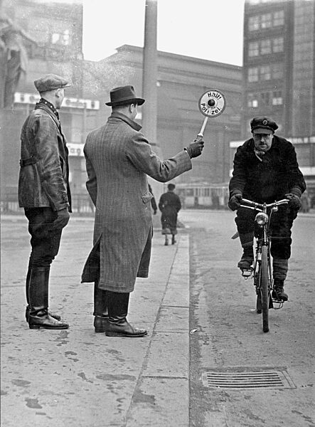 Plain clothes police officers stop a cyclist, 1942