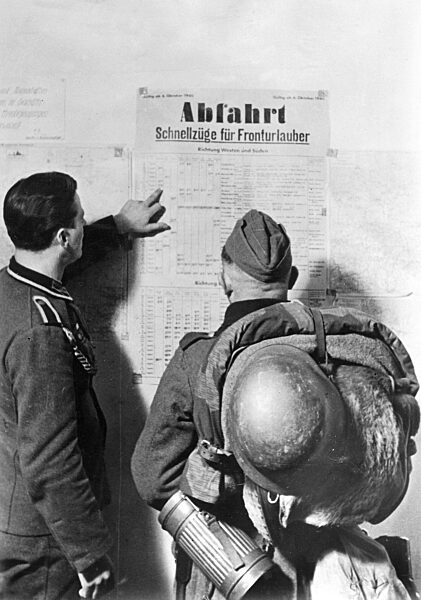 Deutsche Soldaten studieren einen Zugfahrplan