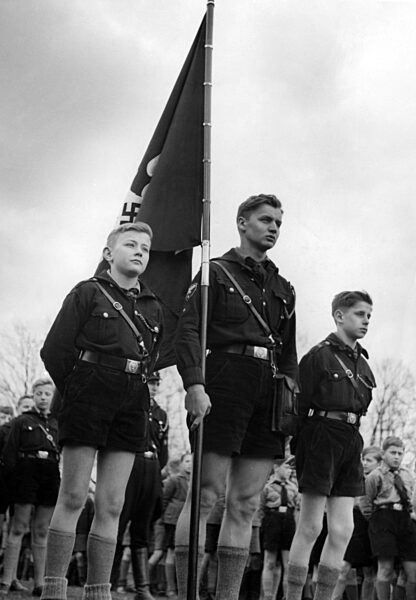 Jungvolk leader and Pimpfe with swastika flag, 1943