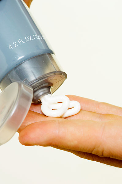 Man squeezing tube of moisturiser