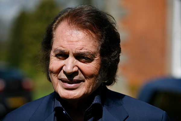 Engelbert Humperdinck poses for a photograph next to his car and a Union Jack flag