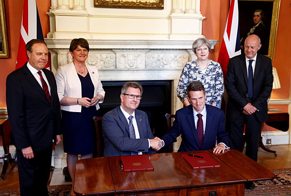 The DUP Jeffrey Donaldson and Gavin Williamson the Chief Whip sign paperwork after Theresa May and her colleagues met with Arlene Foster inside 10 Downing Street as they have finalises a deal to keep the Conservatives in power, June 26 2017. It has been 18 days since the general election which resulted in no party gaining a majority.