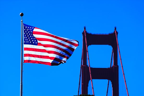 Die Amerikanische Flagge vor einem Teil der Golden Gate Bridge