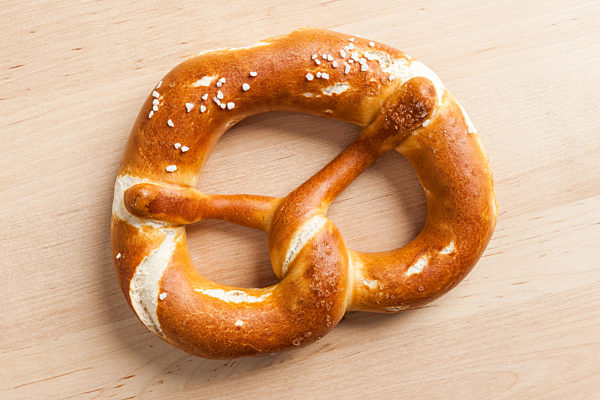 leckere bayerische Brezel auf Holztisch, tasty bavarian pretzel on wooden table