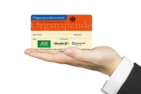 Organspendeausweis der AOK in der Hand, organ donor card of AOK in a hand