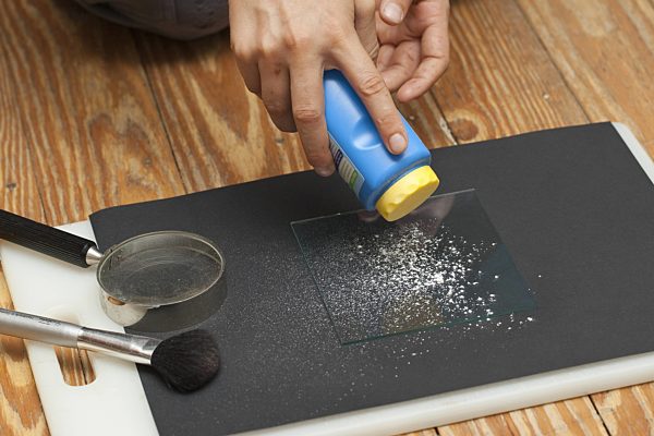 Fingerabdruecke nehmen, 2. Schritt: auf die Glasscheibe wird Puder gestreut, taking fingerprints. Step 2: powder is scattered on a glass panel with a finger-print
