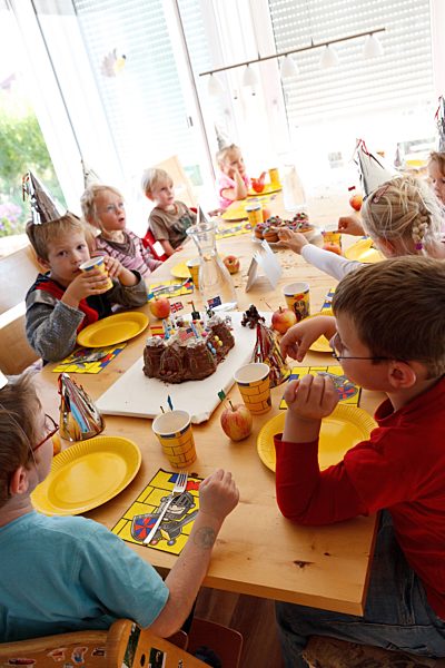 Kinder essen Kuchen auf einem Kindergeburtstag, children eating cake on child's birthday