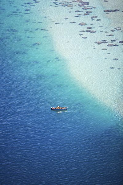 kleines Boot an einem Traumstrand im Indischen Ozean, Small boat in turquoise waters if Indian ocean