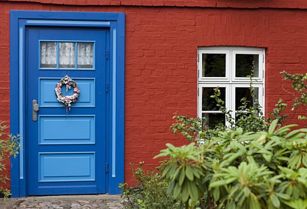 Blick auf die blau bemalte Tür eines roten Ostseehauses, aufgenommen am 18...