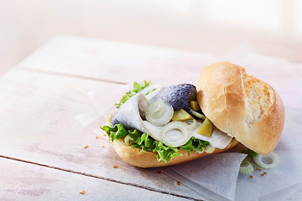 Baguettebrötchen mit Bismarkhering, Gewürzgurke, Salat und Zwiebeln