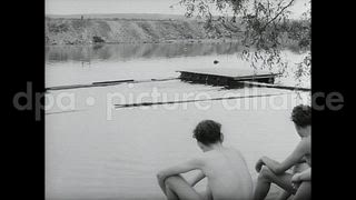 July 27, 1954 – Wiesbaden Germany: Couples drink while talking and swimmers in a pool of water in Wiesbaden, Germany.