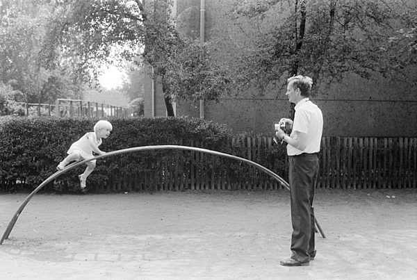 Vater mit Kind auf einem Spielplatz in Halle (Saale) im Bundesland Sachsen-Anhalt auf dem Gebiet der ehemaligen DDR, Deutsche Demokratische Republik