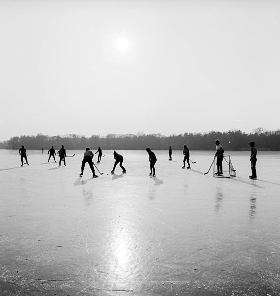 Jugendliche spielen Eishockey auf dem zugefrorenen Motzener See in Zossen im Bundesland Brandenburg auf dem Gebiet der ehemaligen DDR, Deutsche Demokratische Republik