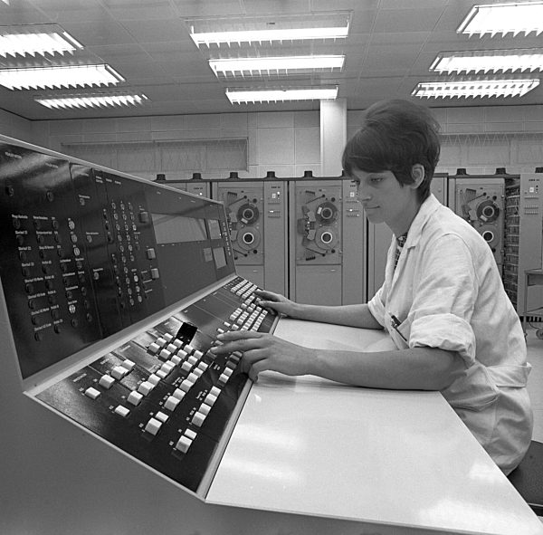 Eine Frau sitzt im Rahmen ihrer EDV-Weiterbildung an einem Großrechner R3000...