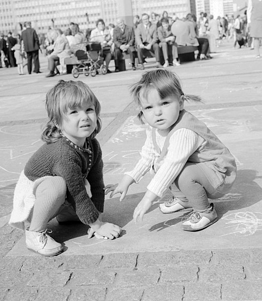Kleine Kinder malen mit Kreide auf dem Alexanderplatz in Berlin, der ehemaligen Hauptstadt der DDR, Deutsche Demokratische Republik