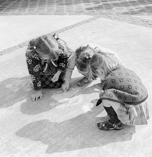 Kleine Kinder malen mit Kreide auf dem Alexanderplatz in Berlin, der ehemaligen Hauptstadt der DDR, Deutsche Demokratische Republik