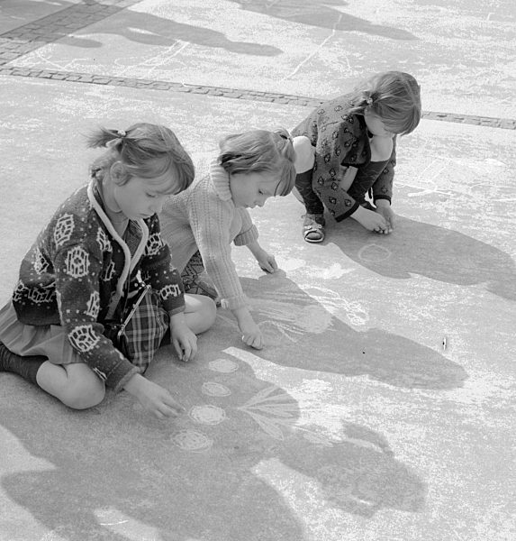 Kleine Kinder malen mit Kreide auf dem Alexanderplatz in Berlin, der ehemaligen Hauptstadt der DDR, Deutsche Demokratische Republik