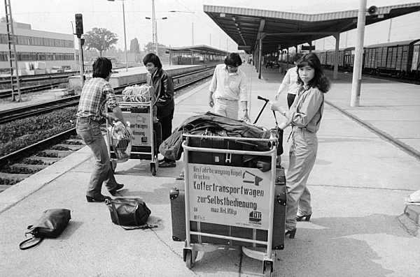 Vietnamesische Gastarbeiter auf dem Bahnhof Flughafen Berlin-Schönefeld in Schönefeld im Bundesland Brandenburg auf dem Gebiet der ehemaligen DDR, Deutsche Demokratische Republik