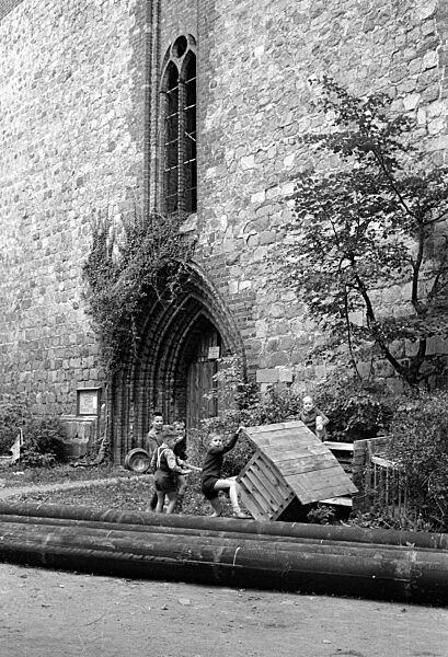 Spielende Kinder an der St.-Peter-Kirche in Altentreptow, 1963
