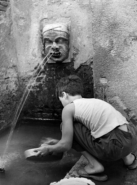 Kind an einem Brunnen in Italien