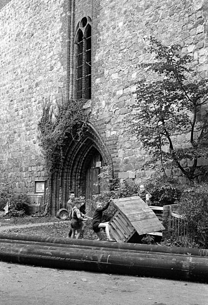 Spielende Kinder an der St.-Peter-Kirche in Altentreptow, 1963