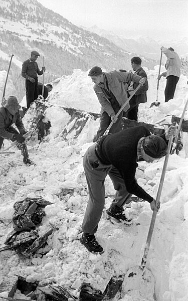 Nach dem Lawinenabgang graben sich Retter zu einem Gebäude durch, 1954