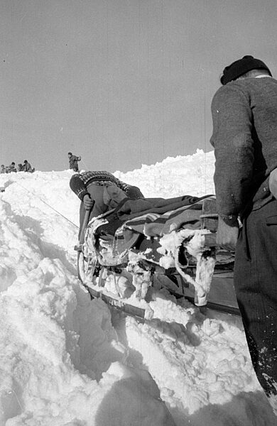Helfer transportieren nach der Lawinenkatastrophe in Vorarlberg Decken auf einem Schlitten, 1954