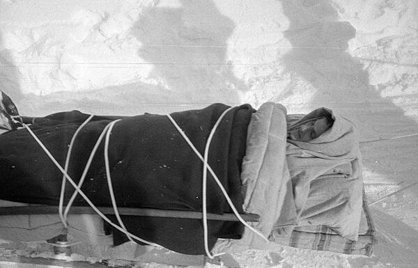 Gerettetes Lawinenopfer auf einem Rettungsschlitten nach Lawinenabgang bei Blons, 1954