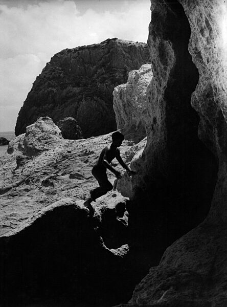 Junge klettert auf einem Felsen auf der Insel Ponza