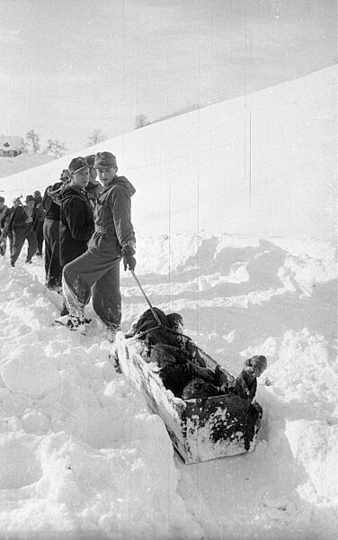 Rettungstrupp mit geborgenem Opfer nach Lawinenabgängen bei Blons, 1954