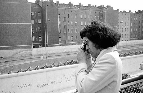 Frau fotografiert im Bezirk Mitte über die Mauer