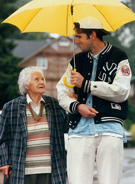 Young man walking with an old woman