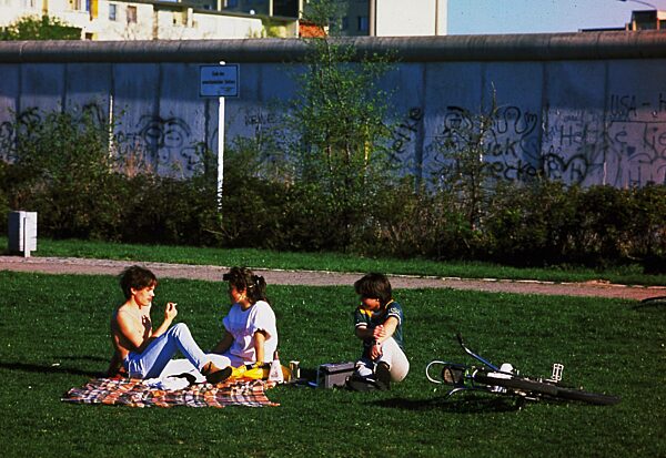 Jugendliche vor der Berliner Mauer