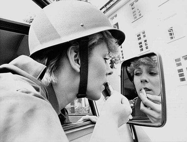 Woman making up in the mirror