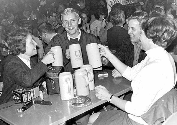 Menschen feiern auf dem Oktoberfest in München, 1969