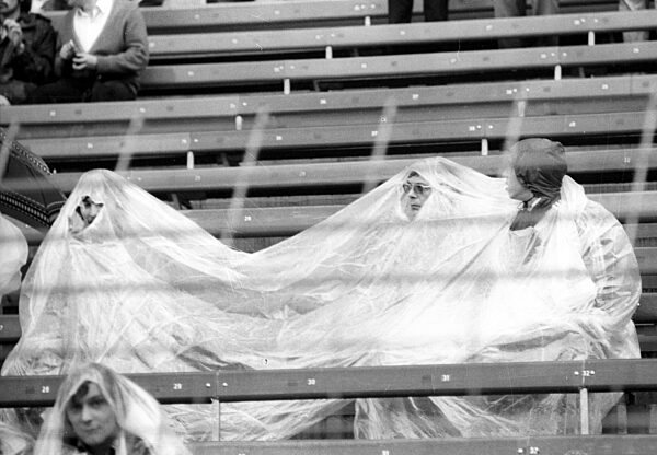 Soccer World Cup 1974 2nd round / BR Germany - Sweden 4:2 / 30.06.1974 in Duesseldorf / spectators , fans seek shelter from the rain under a tarp or rain capes.