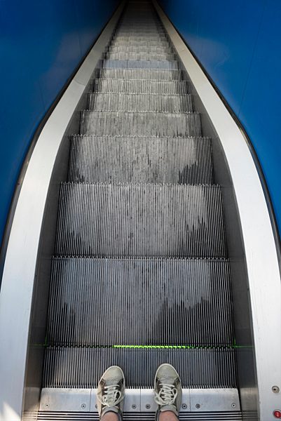 Man shoes standing on a escalator