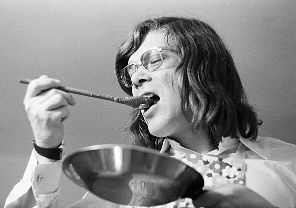 Siebziger Jahre, Menschen, junger Hobbykoch schmeckt das Essen mit einem Holzloeffel auf die richtige Wuerze ab, Wilfried