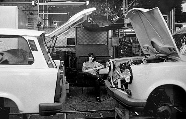 Eine Arbeiterin sitzt auf einem Stuhl an der Produktionsstrecke für den Pkw...