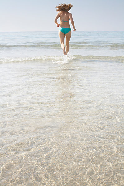 Woman running into sea